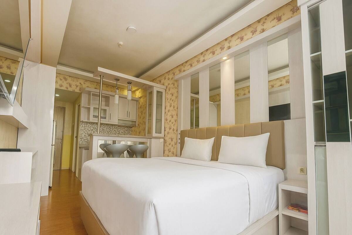 A modern bedroom with a large bed, a bedside table, and a built-in wardrobe.