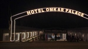 L’entrée de l’hôtel Omkar Palace, surmontée d’une arche portant une enseigne.