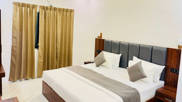 Une chambre moderne avec un grand lit, une tête de lit en bois et un ventilateur de plafond.