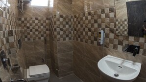 A modern bathroom with a shower, toilet, and sink. - Hotel Shree Mani Residency (Ranchi)