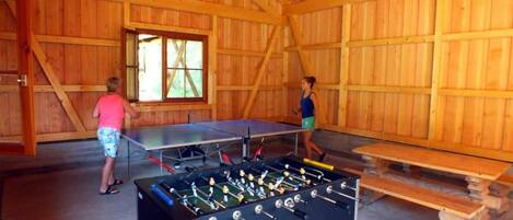 Un espace intérieur avec des murs en bois et une table de baby-foot.