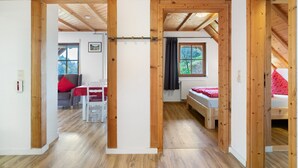 A room with wooden beams, a bed, a table, and a window. - Apartment 'Talblick' with Shared Terrace, Garden, and Wi-Fi (Gengenbach)