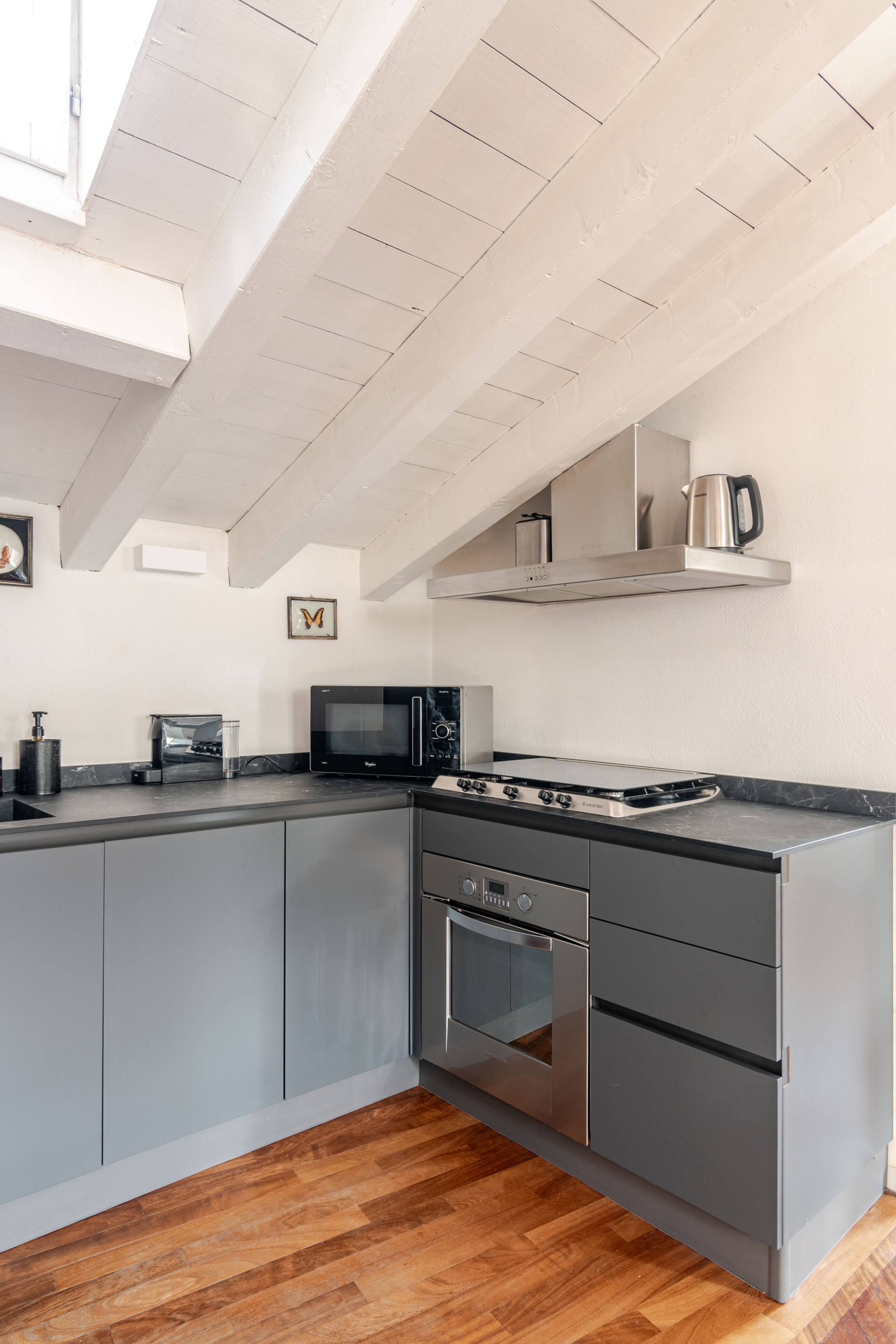 Una cucina moderna con microonde, fornello e forno integrati.