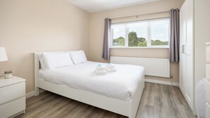 A bedroom with a bed, a nightstand, a window with curtains, and a radiator. - 3 Bed Home W/Garden By Phoenix Park & Dublin Zoo (Sublin 7)