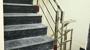 Eine Treppe mit schwarzen Marmorstufen und einem Metallgeländer.