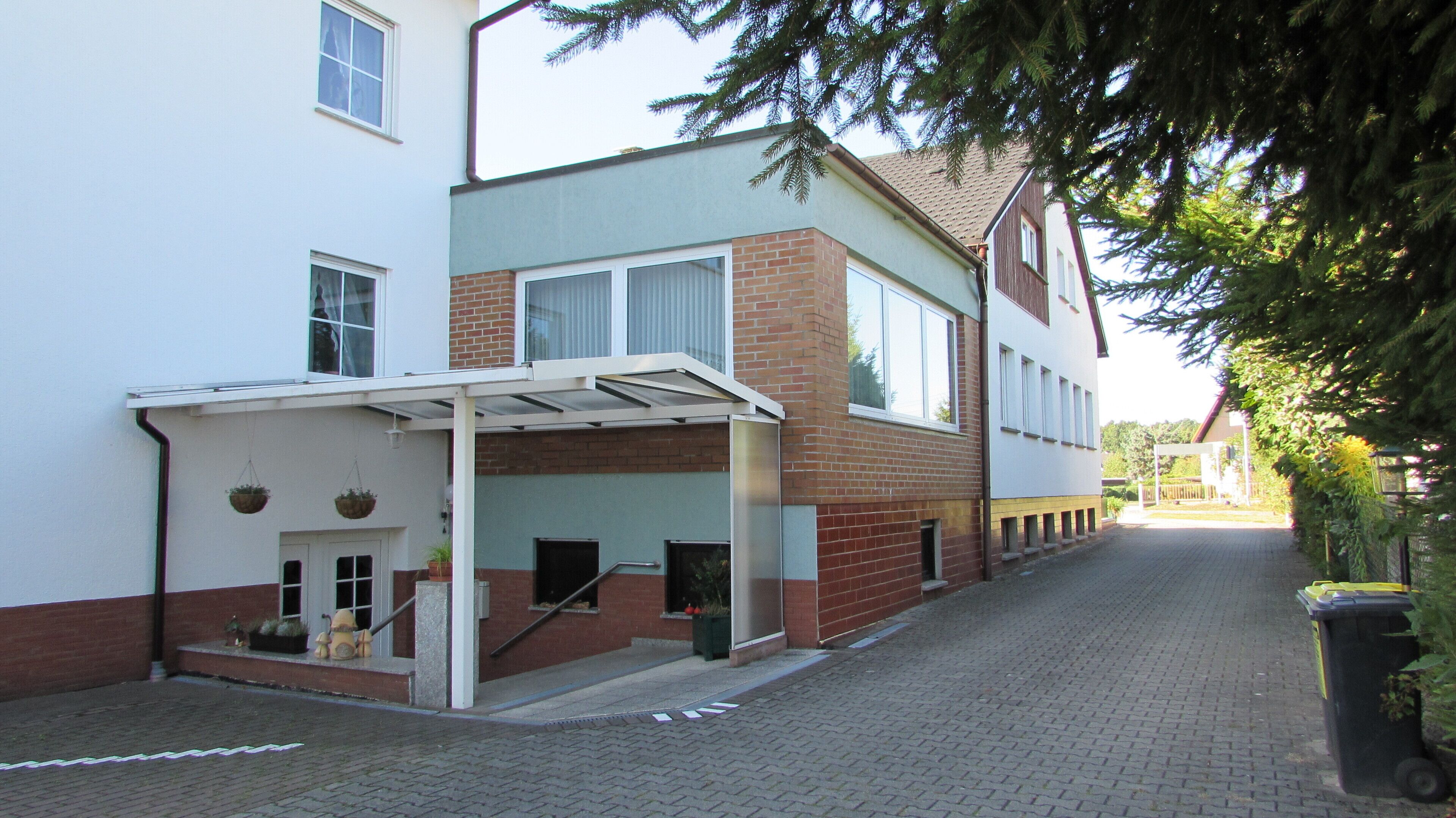 A two-story building with a covered entrance and a brick facade.