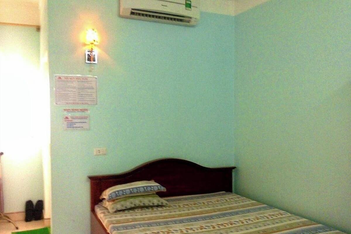 Ein Zimmer mit einem Bett, einer Klimaanlage und einer Wandleuchte.