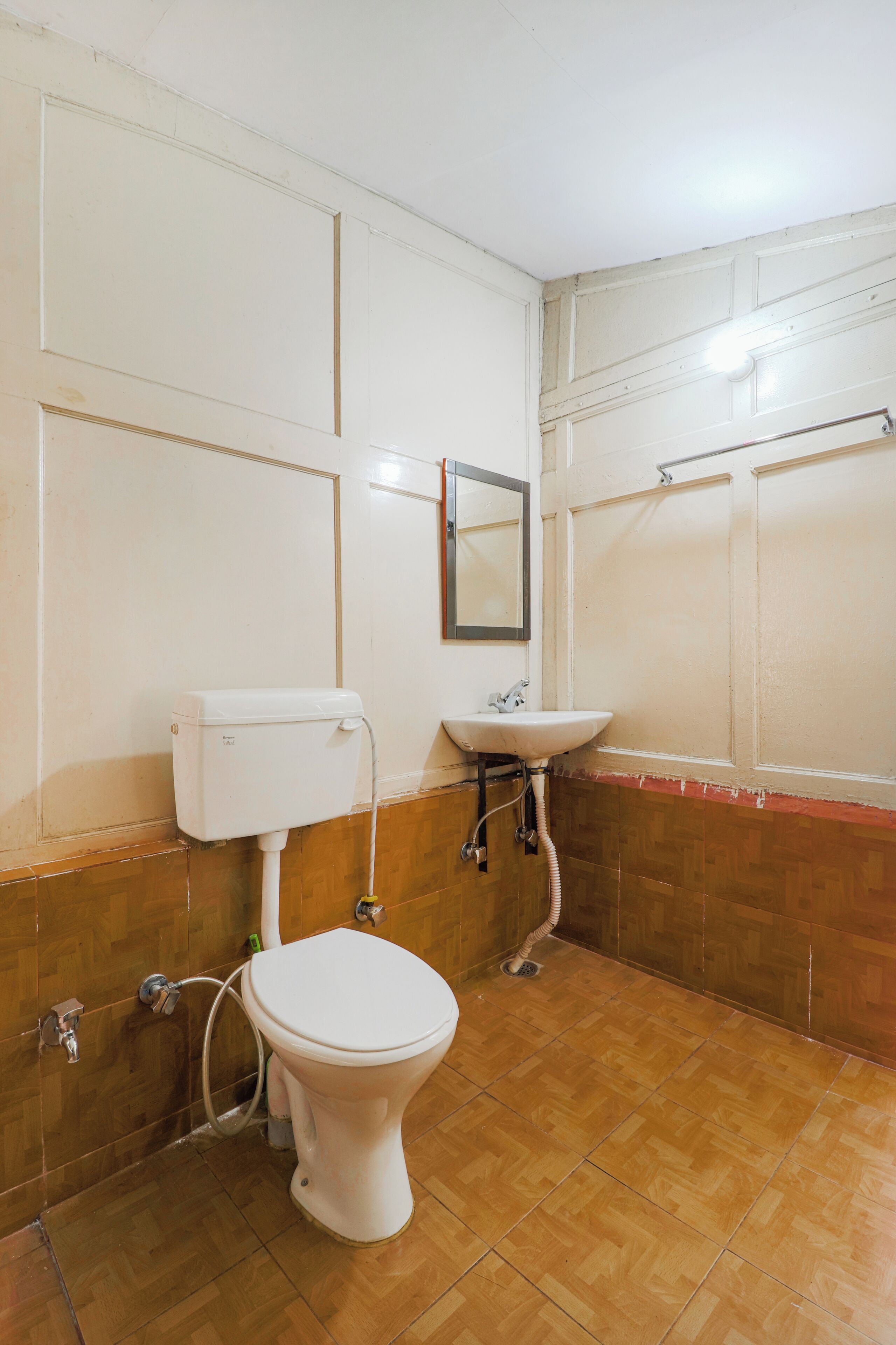 Une salle de bain avec des toilettes, un lavabo et un miroir.