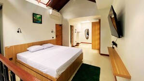 Un dormitorio con una cama de madera, una alfombra verde, un televisor en la pared y un cuadro en la pared.