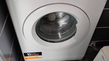 Vue de face d’un lave-linge Indesit blanc, doté d’un panneau de commande numérique, d’une capacité de 9 kg et d’un autocollant indiquant une garantie de 10 ans.