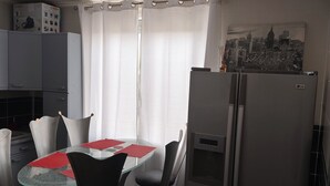 Una cocina compacta con una mesa, sillas, un refrigerador y un módulo de Bosch.