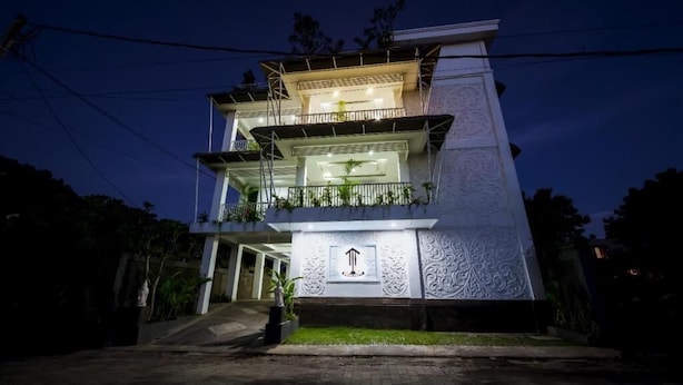 Un edificio de varios pisos con una escalera central que conduce a la entrada.