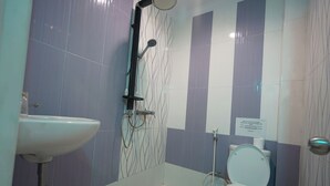 Un baño con ducha, inodoro y lavamanos.