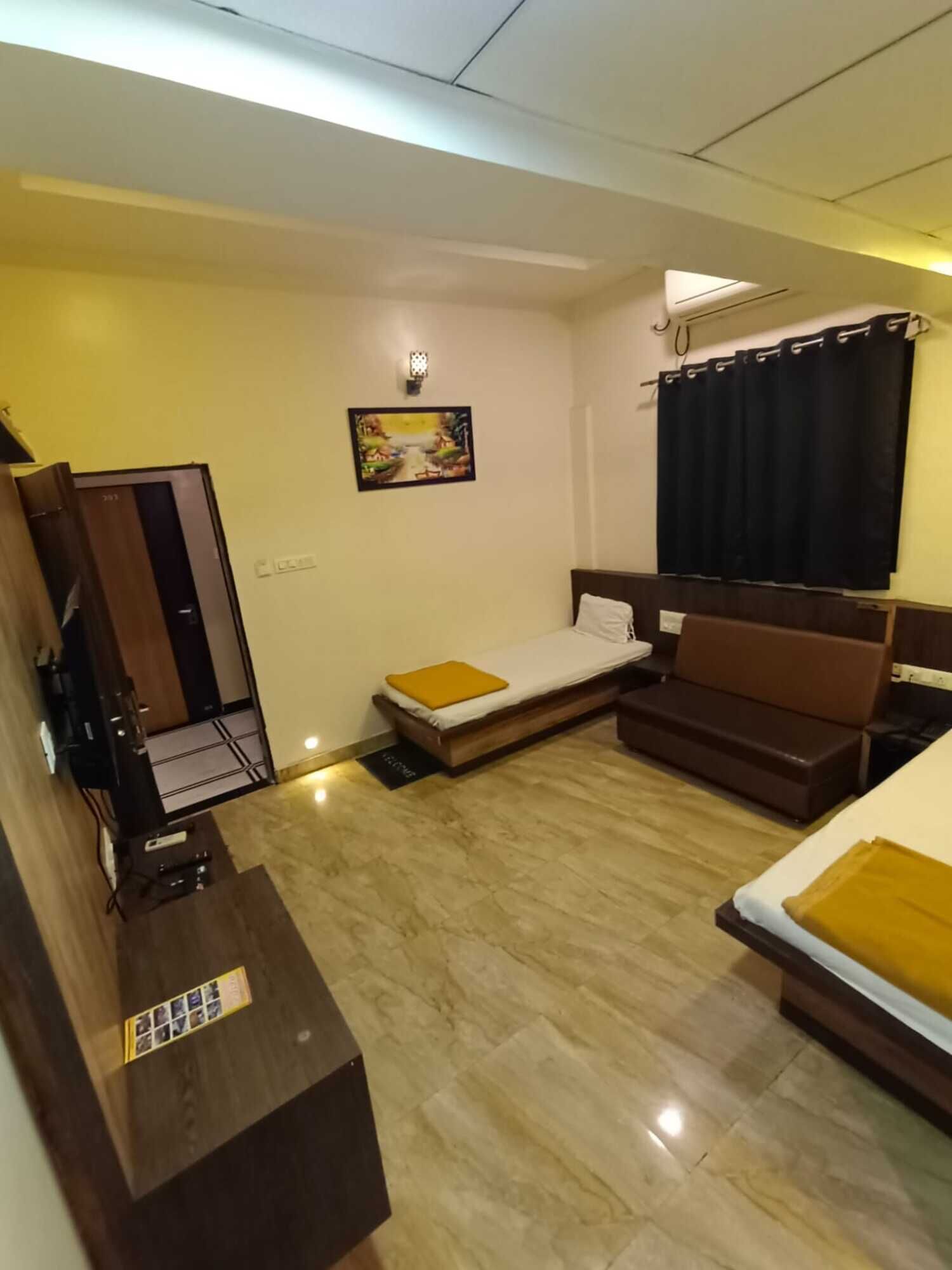 Habitación de hotel con cama, sofá, escritorio y un cuadro en la pared.