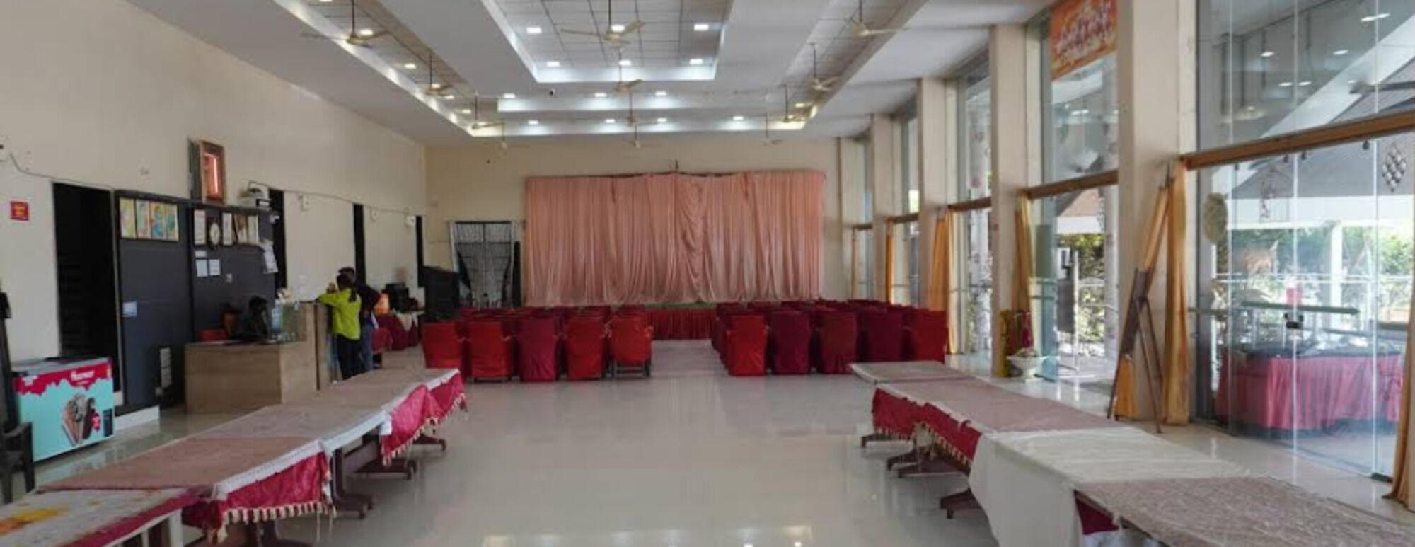 A conference room with a stage, tables, and chairs.