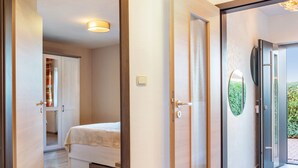 Un dormitorio con cama, una puerta que da a un balcón y una lámpara en el techo.