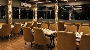Een restaurantinterieur met houten vloeren, comfortabele stoelen en gedekte tafels.