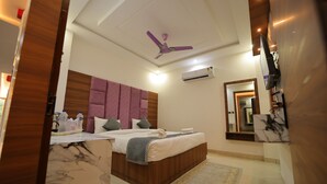A modern hotel room with a large bed, a ceiling fan, an air conditioning unit, and a marble-patterned floor.