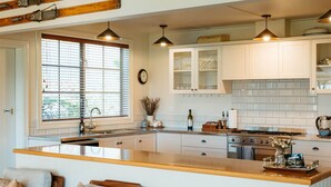 A kitchen with white cabinets, a central island, a sink, and a stove.