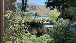 Vista de un paisaje montañoso con un lago azul cristalino, rodeado de exuberante vegetación y árboles.