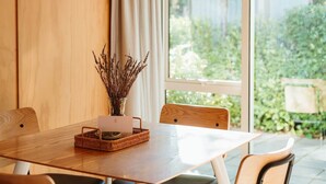 A dining table with chairs, a basket, and a vase with dried plants. - Awa Cottage - Lake Tekapo (Lake Tekapo)