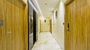 Un pasillo con puertas de madera y suelo de mármol.