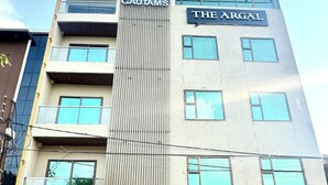 Un edificio de varios pisos con un cartel que indica "THE ARGAL" y "GAUTAMS" en la fachada.