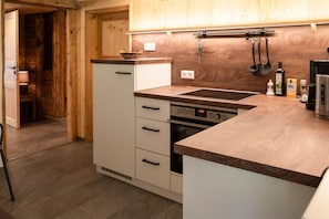 A kitchen with wooden cabinets, a built-in oven, a sink, and a countertop.