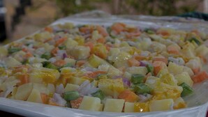 A tray of mixed fruit salad with various diced fruits and vegetables. - Home of Comfort (Narok County)