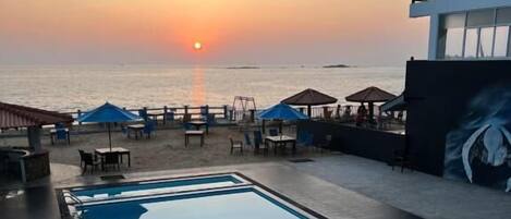 Piscine extérieure, parasols de plage, chaises longues