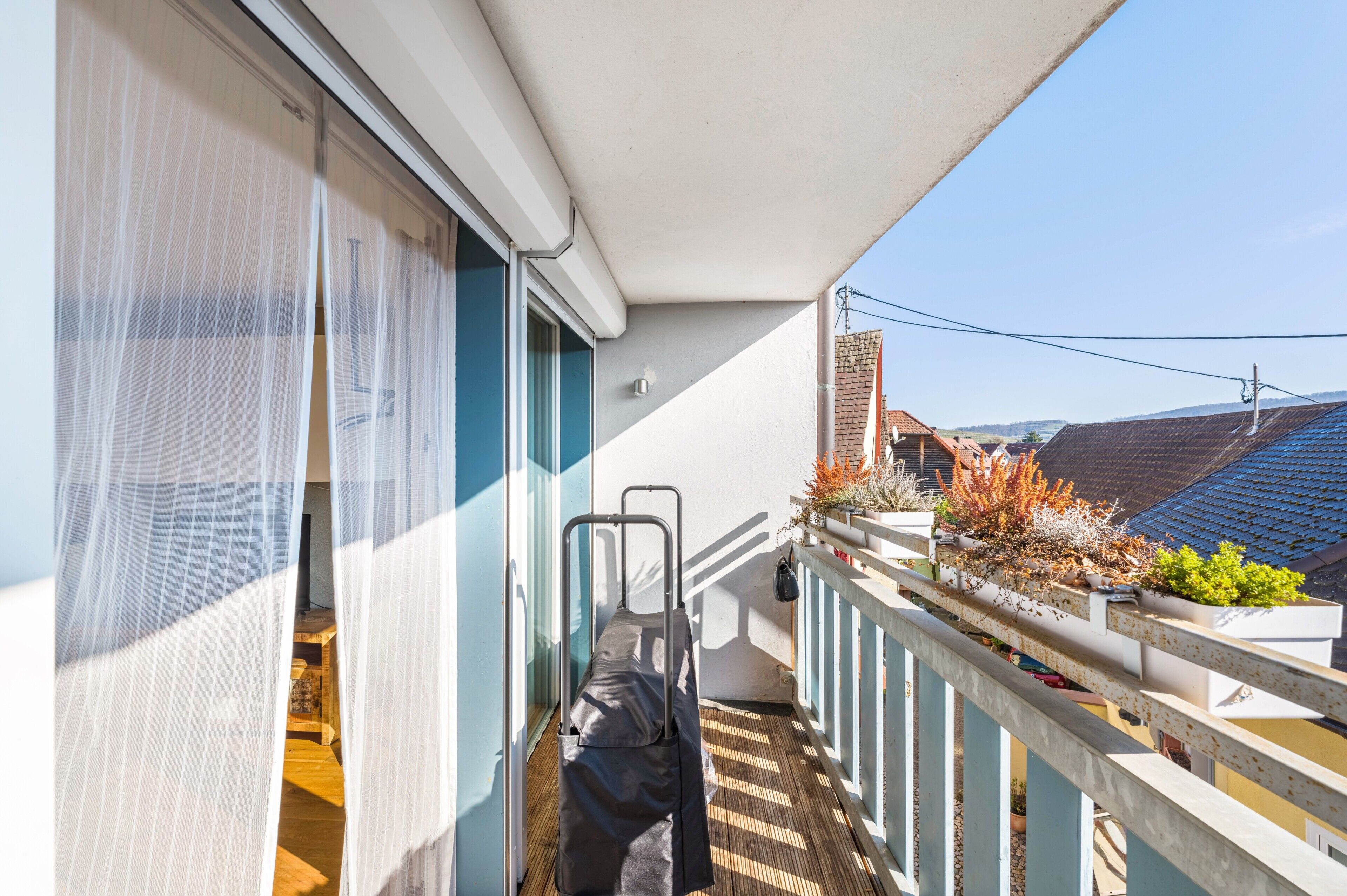 Ein Balkon mit Blick auf die Stadt, ein kleiner Tisch und ein Stuhl.