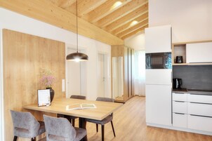 Una cocina moderna con armarios blancos, microondas y cafetera.