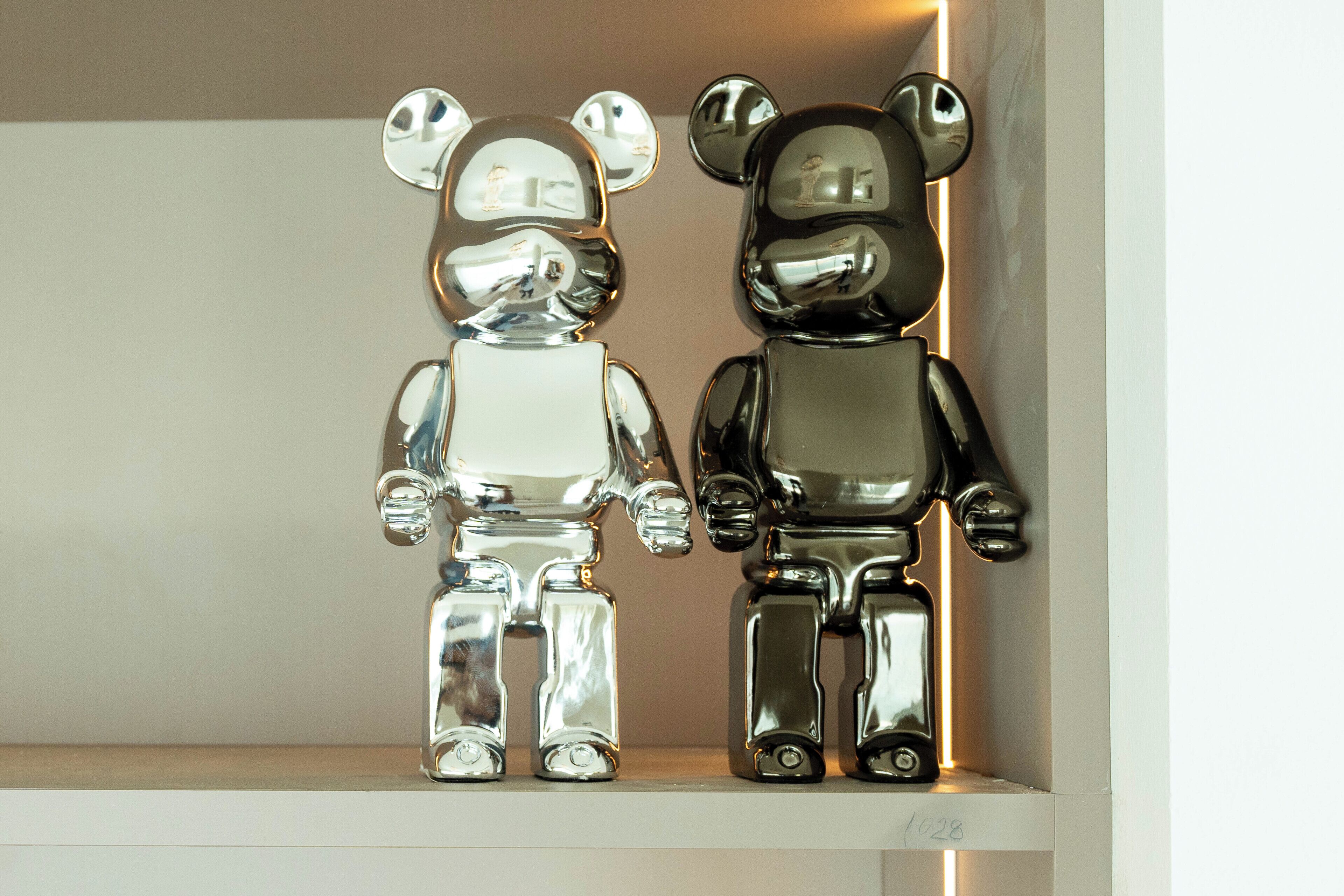Two metallic bear-shaped figures on a shelf.