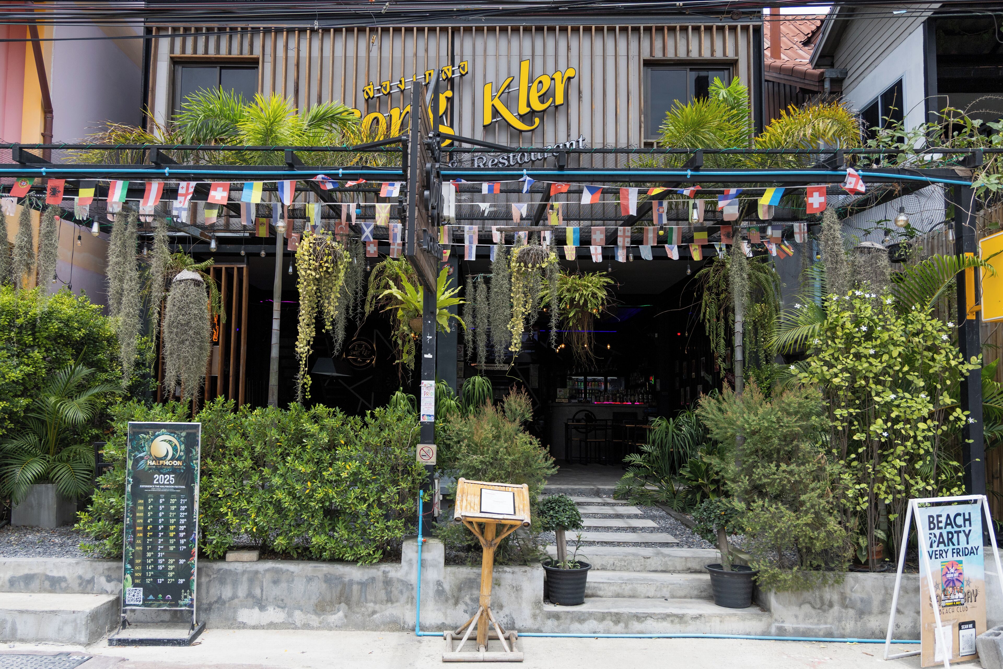Un restaurante con un letrero que dice "Kler Restaurant" y un letrero que anuncia "Fiesta en la Playa Todos los Viernes".