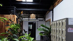 A hallway with lockers, potted plants, and a hanging light fixture. - SongKler (Ko Pha-ngan)