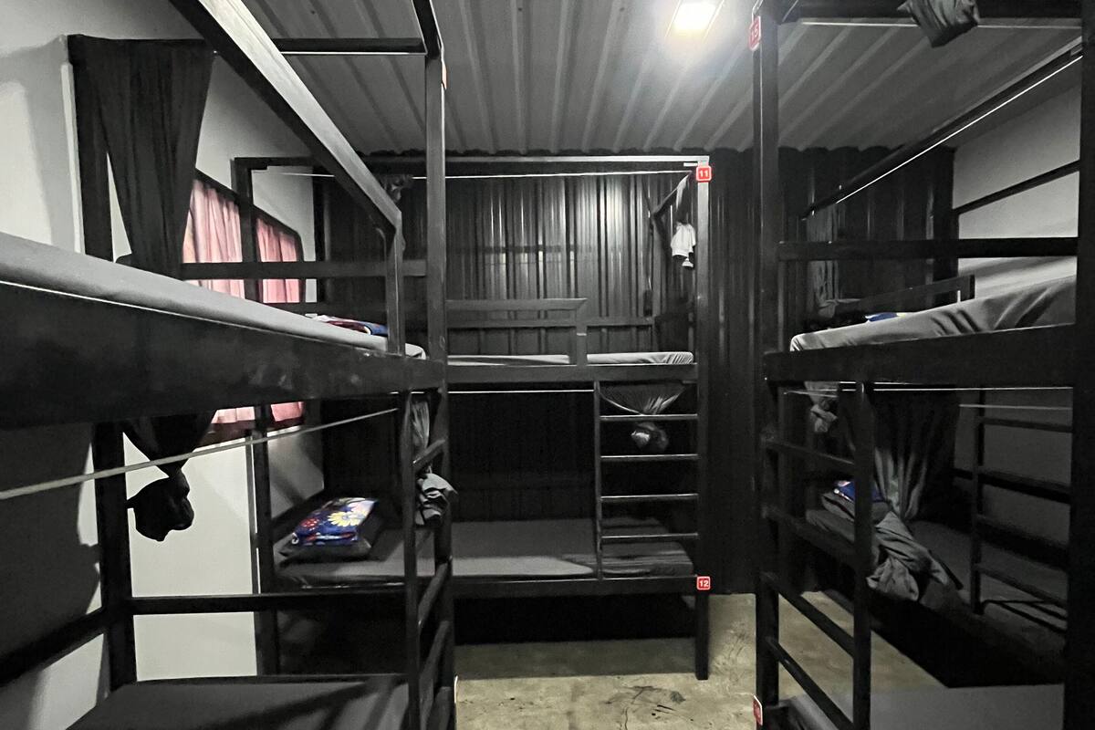 A bunk bed room with a concrete floor and metal railings.