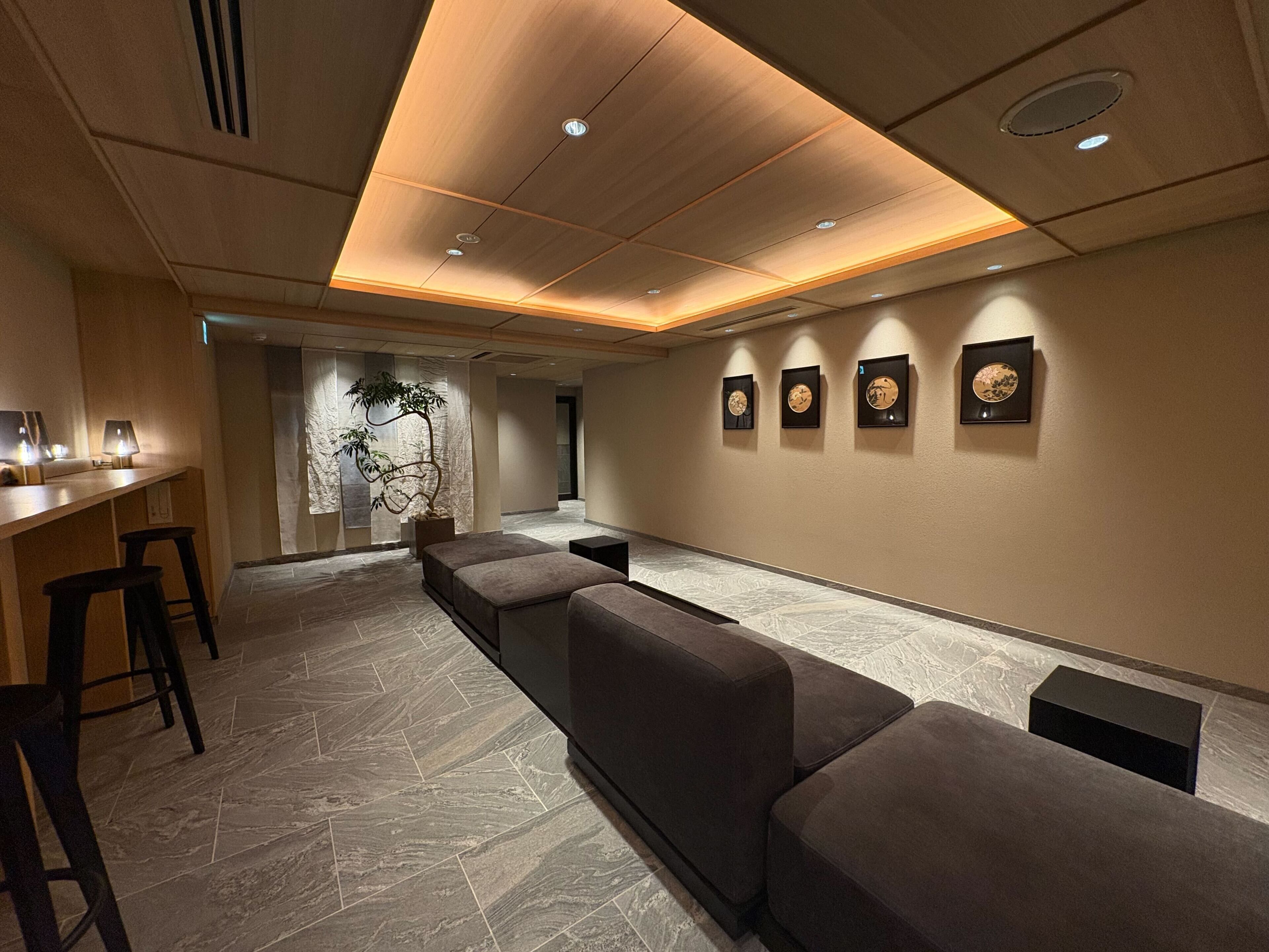 A modern hotel lobby with a reception desk, seating area, and wall-mounted artwork.