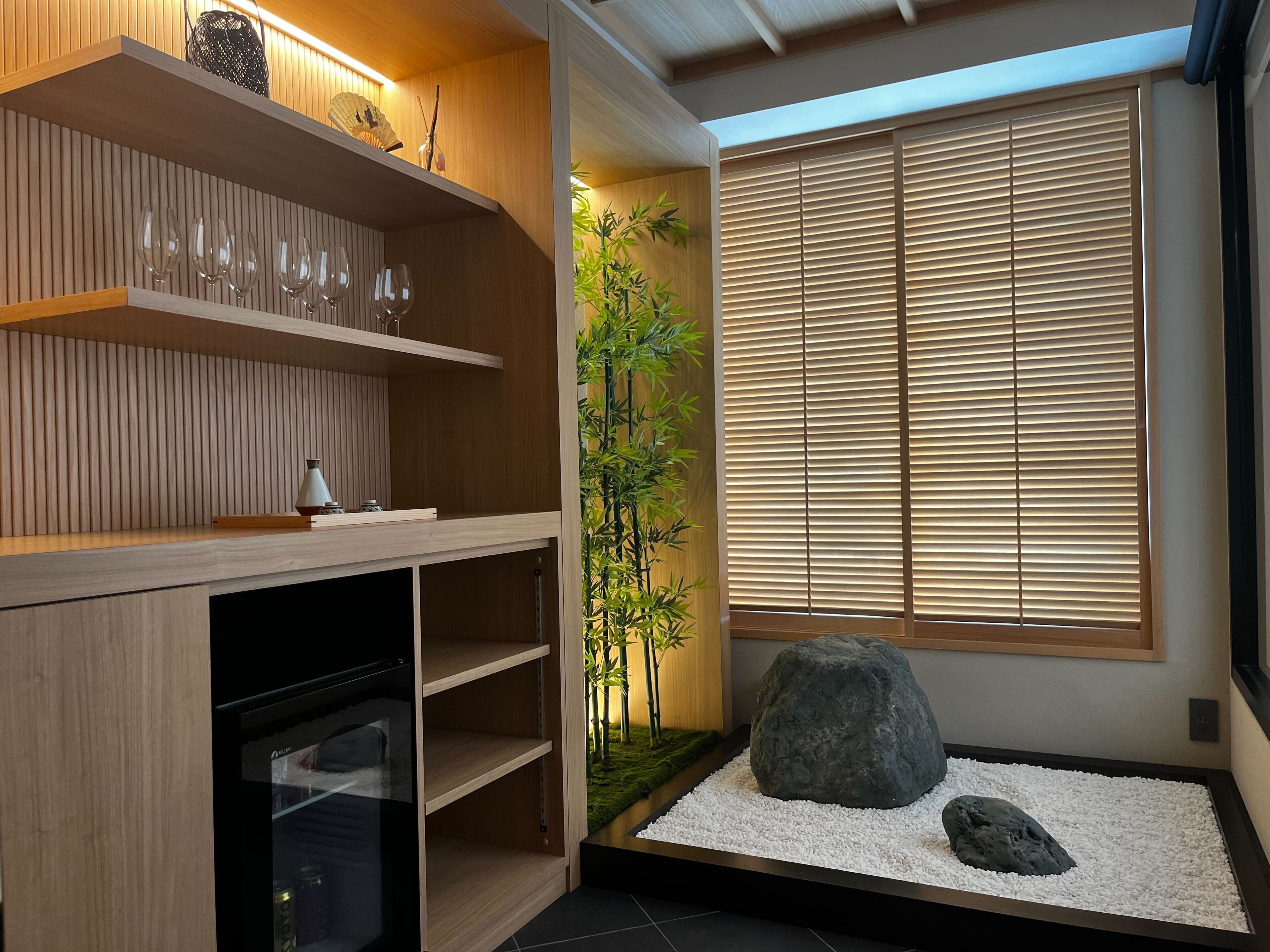 Een modern interieur met houten planken, een glazen kast, bamboe planten en een rotstuin.