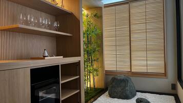 Een modern interieur met houten planken, een glazen kast, bamboe planten en een rotstuin.
