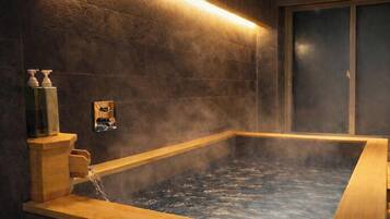 A hot tub with steam, wooden benches, and a wall-mounted pump.