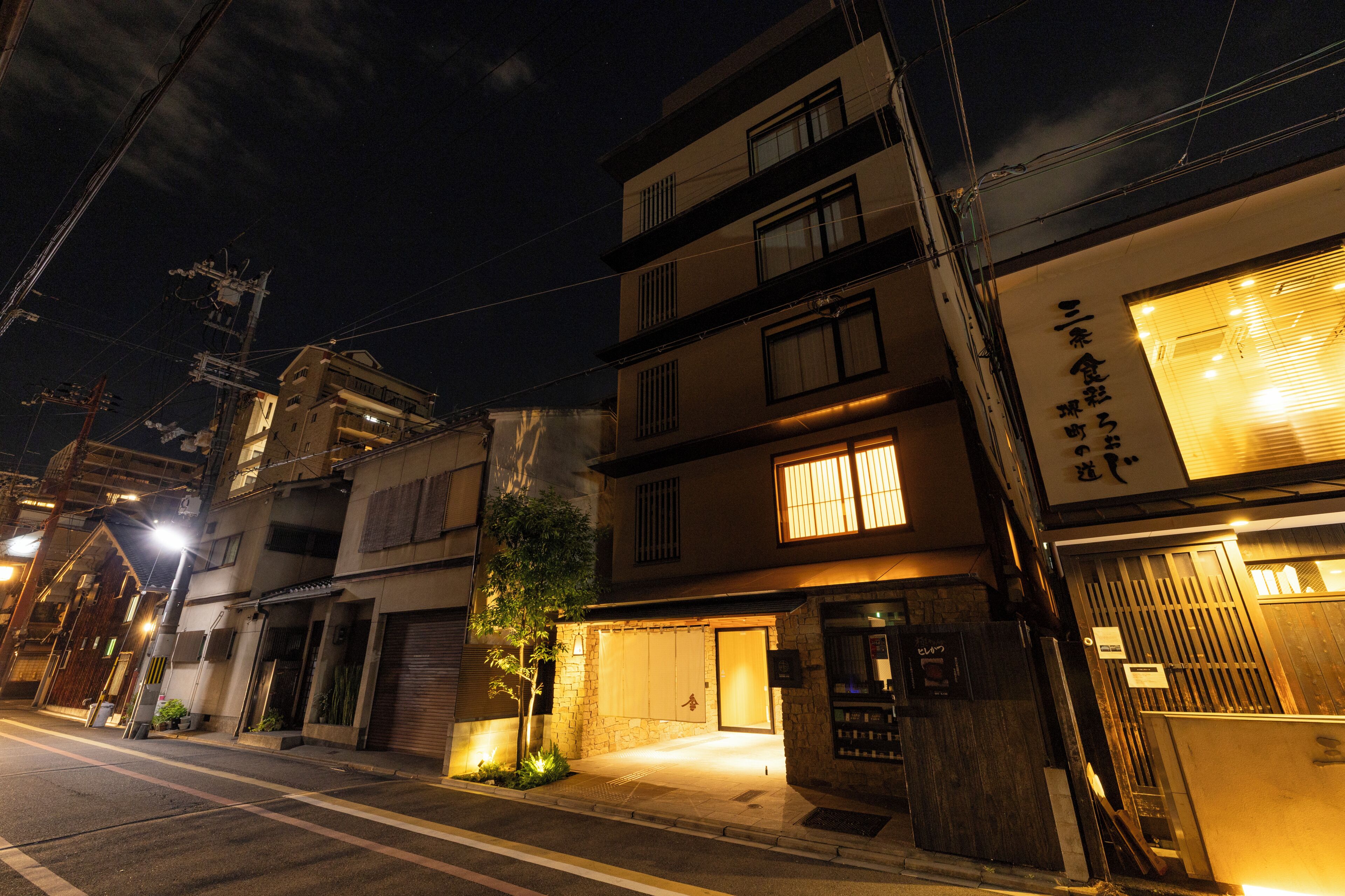 A multi-story building with a garage entrance, a small tree, and a street lamp.