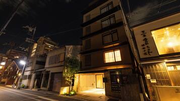 A multi-story building with a garage entrance, a small tree, and a street lamp.