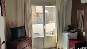 A bedroom with a bed, a dresser, a desk, a television, and a window with curtains. - Chambre 2 lit simple avec balcon (Lézignan-Corbières)