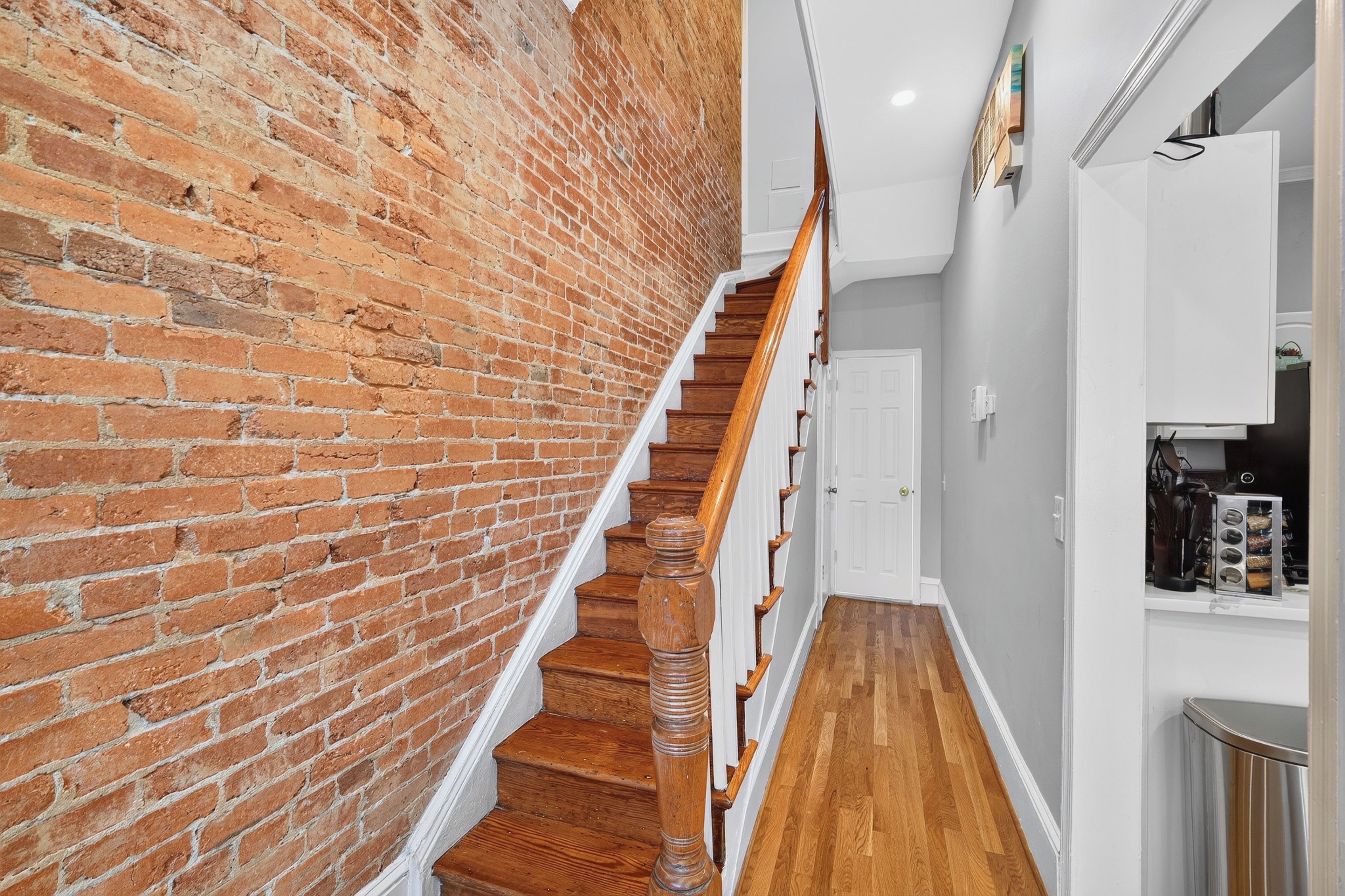 A staircase with wooden steps and a brick wall on one side.