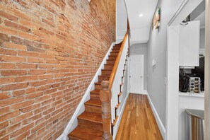 A staircase with wooden steps and a brick wall on one side.