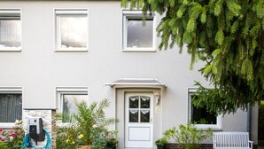 A house with a front door, windows, a bench, and a charging station. - Apartment 'Pleißennest' with Wi-Fi (Chemnitz)