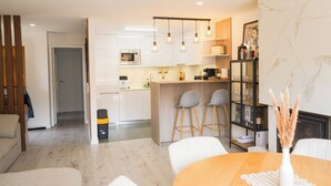 Une cuisine moderne dotée d’un îlot central, de tabourets de bar et de luminaires suspendus.