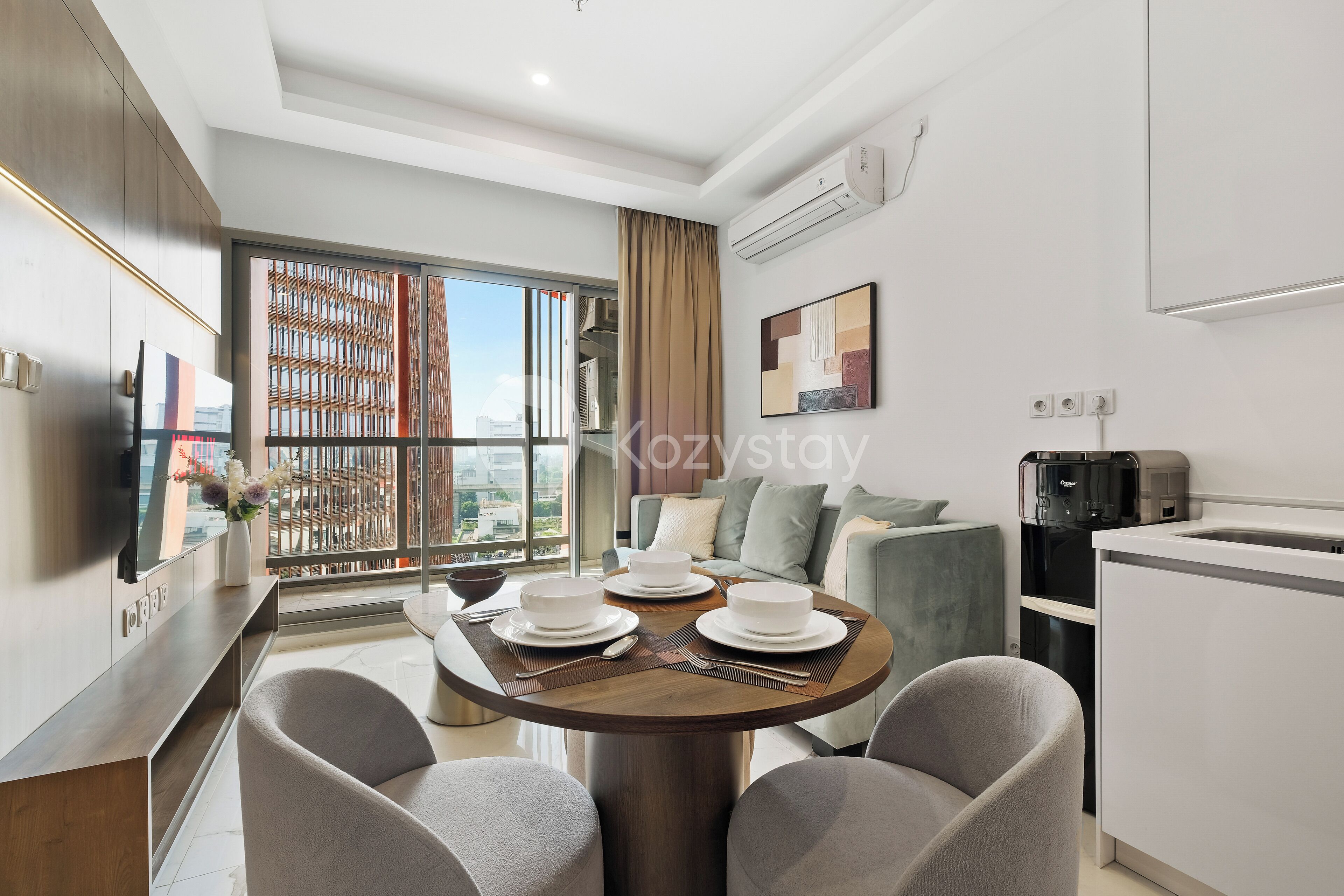 A modern living room with a dining area, large windows, and a view of the city.