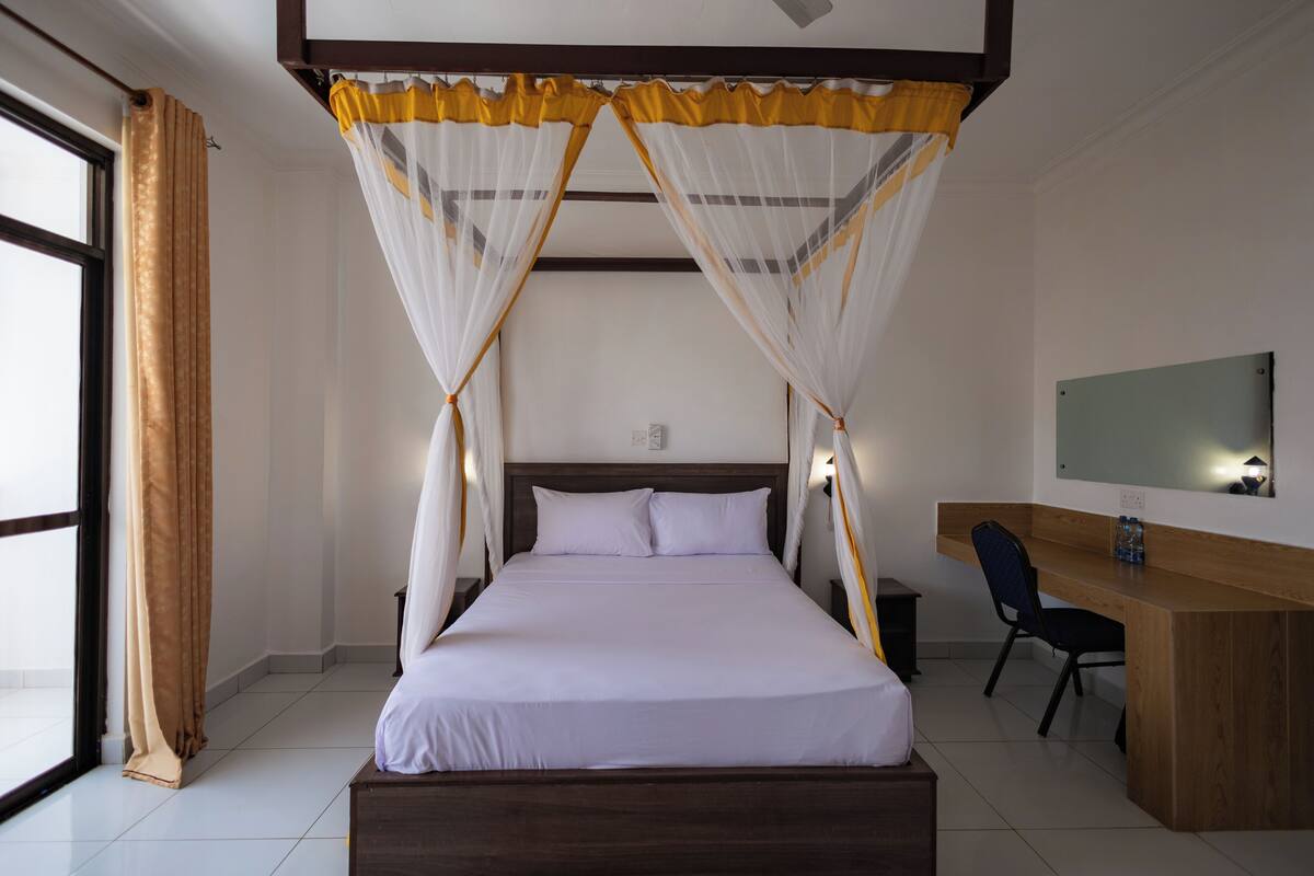 Ein Schlafzimmer mit einem Bett, einem Schreibtisch und einem Stuhl.