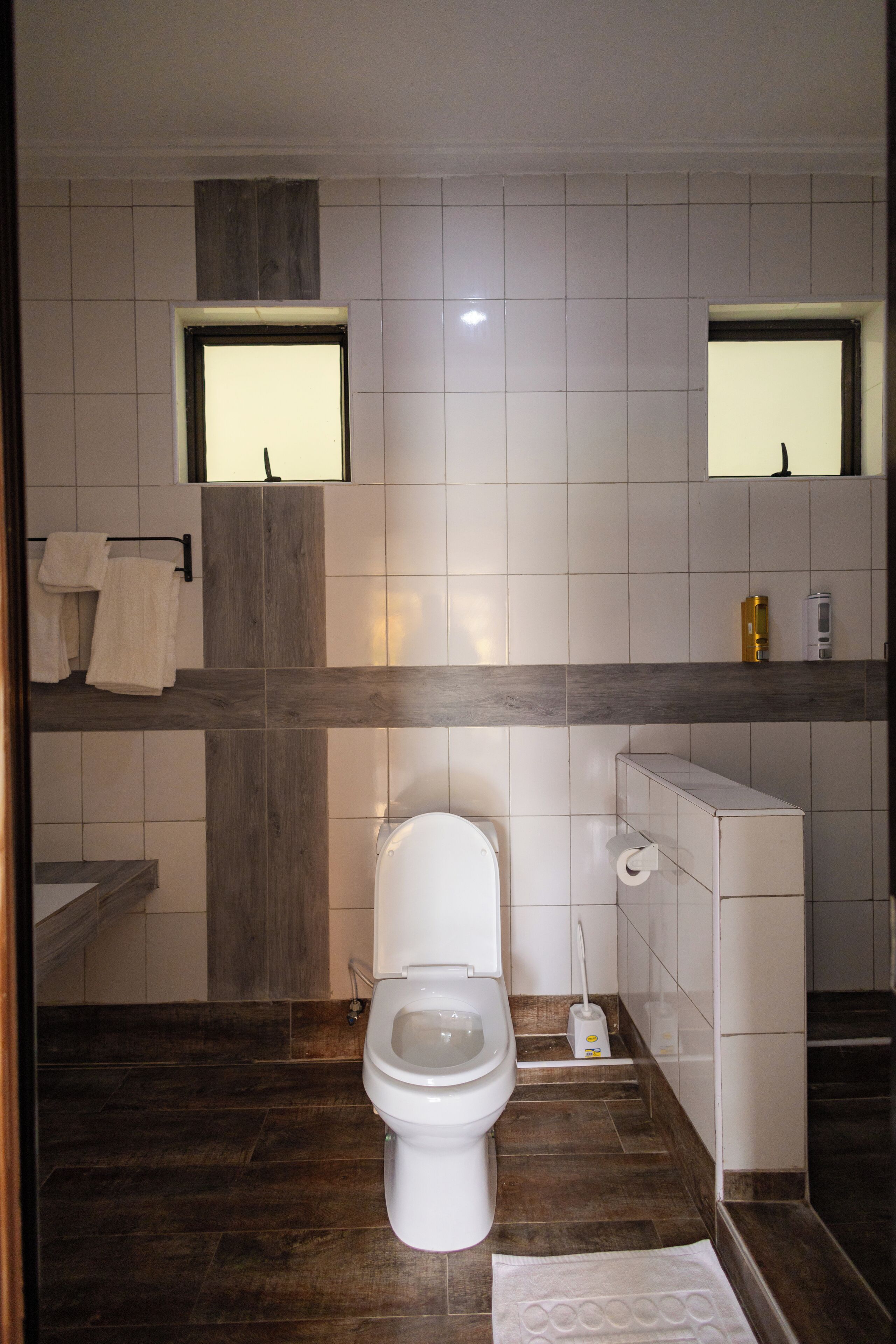 A bathroom with a toilet, a sink, and a mirror.